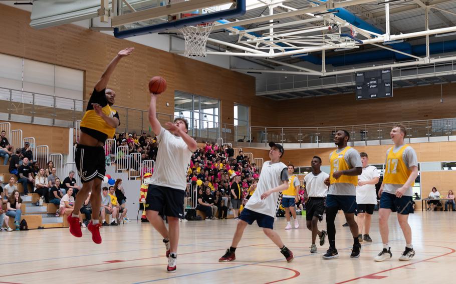 A student goes up for a shot as an airman plays defense in a gym at Spangdahlem Air Base in Germany. 