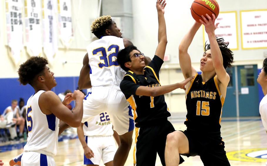 American School In Japan's Kian Takizawa shoots against Yokota's DeShawn Bryant and Zemon Davis during Tuesday's Kanto Plain boys basketball game. The Panthers won 58-26.