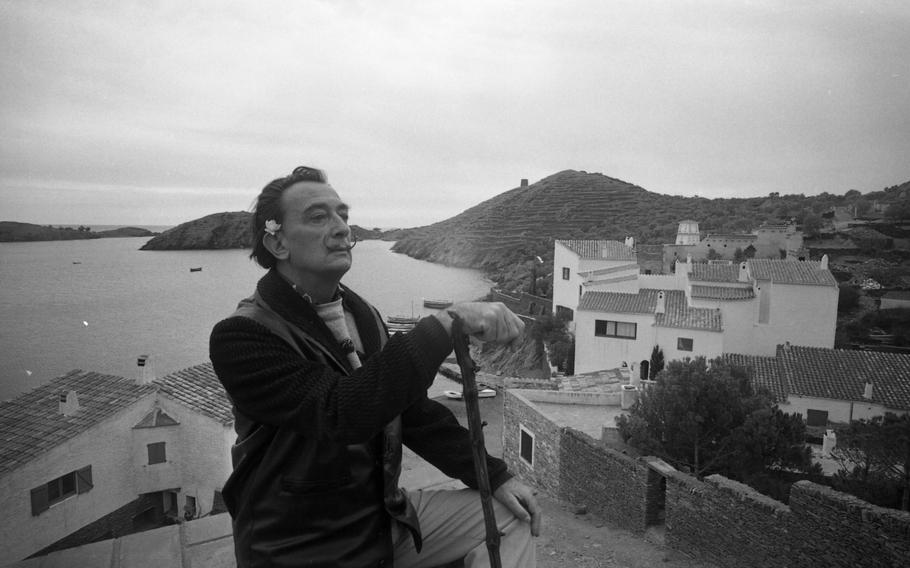 Spanish artist Salvador Dali poses on a hill overlooking his home in Port Lligat, Spain.