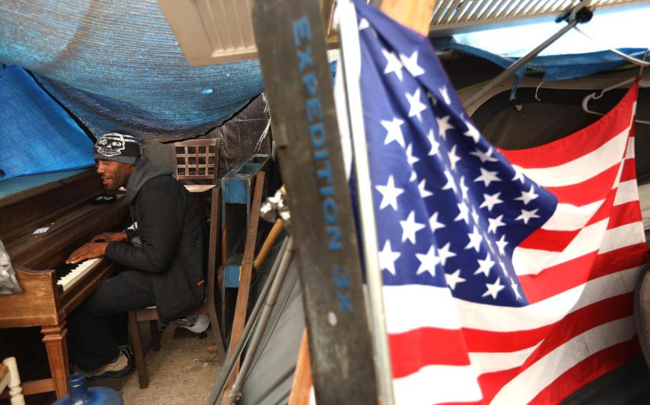 Iraq War veteran Lavon Johnson, 35, plays piano inside his tent along “veterans row” along San Vicente Boulevard in Los Angeles on Oct. 30, 2021. 