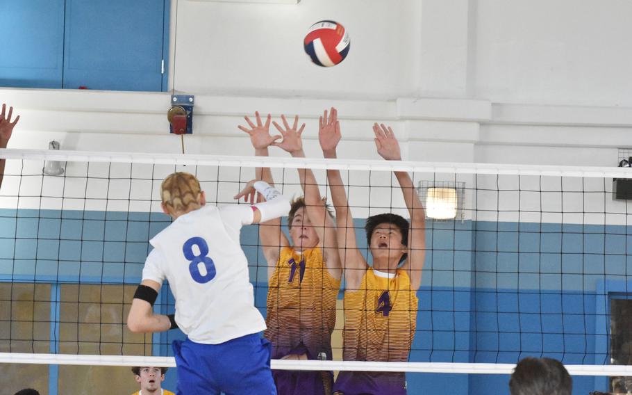 Sigonella’s Christopher Hedemand spikes off the block of Bahrain’s Jake Wade, left, and Jacob Courts in a match Thursday, Oct. 27, 2022.