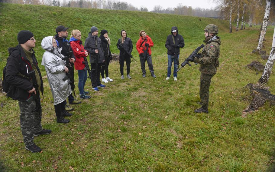 A Polish soldier instructs a group of civilians on how to march through a potentially dangerous area in a two-column formation as part of a familiarization course at the Military University of Technology in Warsaw, Poland, on Nov. 5, 2022. Hundreds of civilians have signed up for shooting lessons, survival skills and gas mask training in recent weeks, with some saying they are motivated by fears of war with Russia.