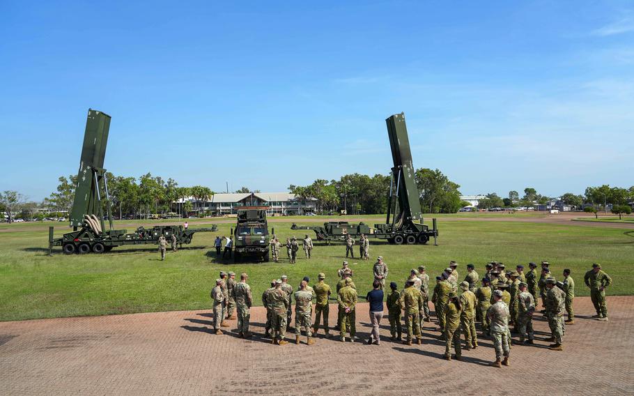 U.S. soldiers brief allied troops no a field near the Dark Eagle hypersonic missile system.