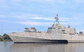 A ship sails through a shipyard.