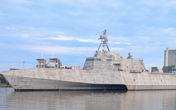 A ship sails through a shipyard.
