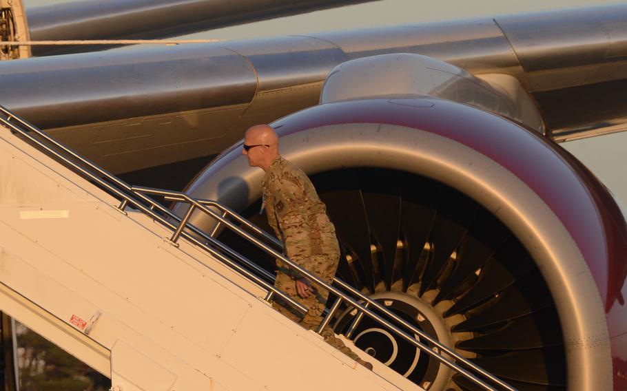 Brig. Gen. Josh Olson, commander of the 86th Airlift Wing, climbs stairs toward an Omni Air International Boeing 777 that was set to carry some 300 Afghans to the U.S. from Ramstein, Saturday, Oct. 9, 2021. The flight was the first to take Afghan refugees from Ramstein to the U.S. in around three weeks. 