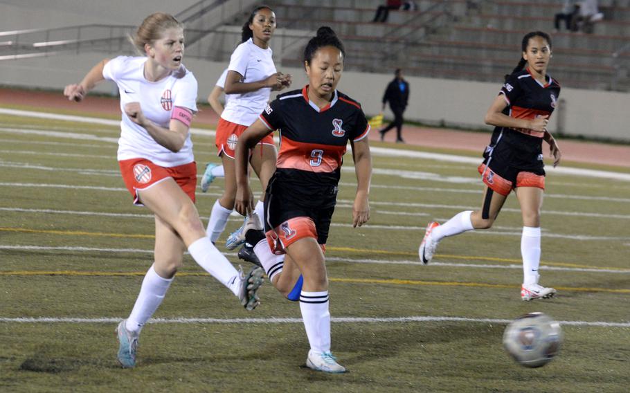 Nile C. Kinnick’s Bree Withers strikes what proved to be the match-winning goal in Friday’s 2-1 victory over Katelyn Mapa and E.J. King.