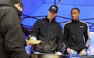 Airmen Ray Ryan, left, and Jeudy Craig, both of Yokota Air Base, Japan, serve meals to homeless people at Ueno Park in Tokyo, March 15, 2024.