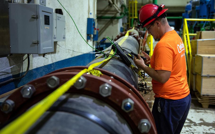 A Navy contractor inspects a water pipe that connects to a granular activated carbon system at the Red Hill well near Joint Base Pearl Harbor-Hickam, Hawaii, in April 2022.