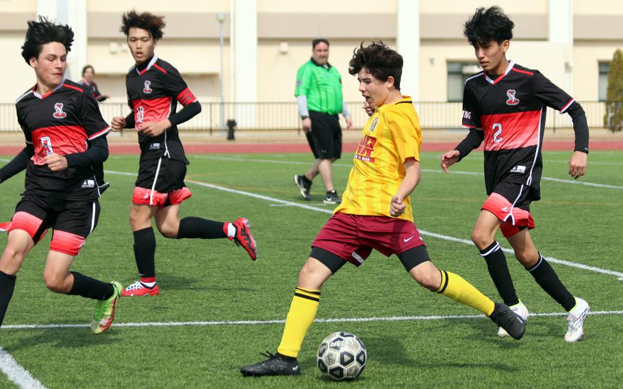 Matthew C. Perry's Shayden Torres drives upfield between three E.J. King defenders during Saturday's Perry Cup Silver Group playoff match. The teams tied 0-0.