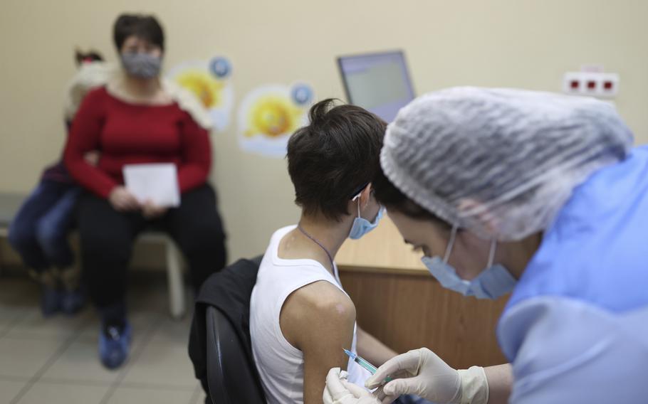 A teenager receives a dose of Russia’s Sputnik M (Gam-COVID-Vac-M) COVID-19 vaccine in Krasnodar, Russia, Friday, Feb. 4, 2022. The Russian president says his government is considering loosening some coronavirus restrictions, even as the country is facing a record-breaking surge of infections because of the highly contagious omicron variant.