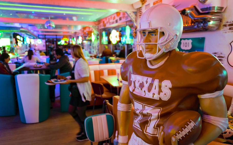 A life-sized statue of a University of Texas football player stands guard among the dining booths at Freeway Restaurant in Ruesselsheim, Germany, adding a quirky touch to the American-themed decor.