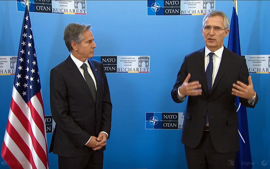 Secretary of State Antony Blinken listens to NATO Secretary-General Jens Stoltenberg speak to reporters before the meeting of the member state foreign ministers in Bucharest, Romania, Nov. 29, 2022.