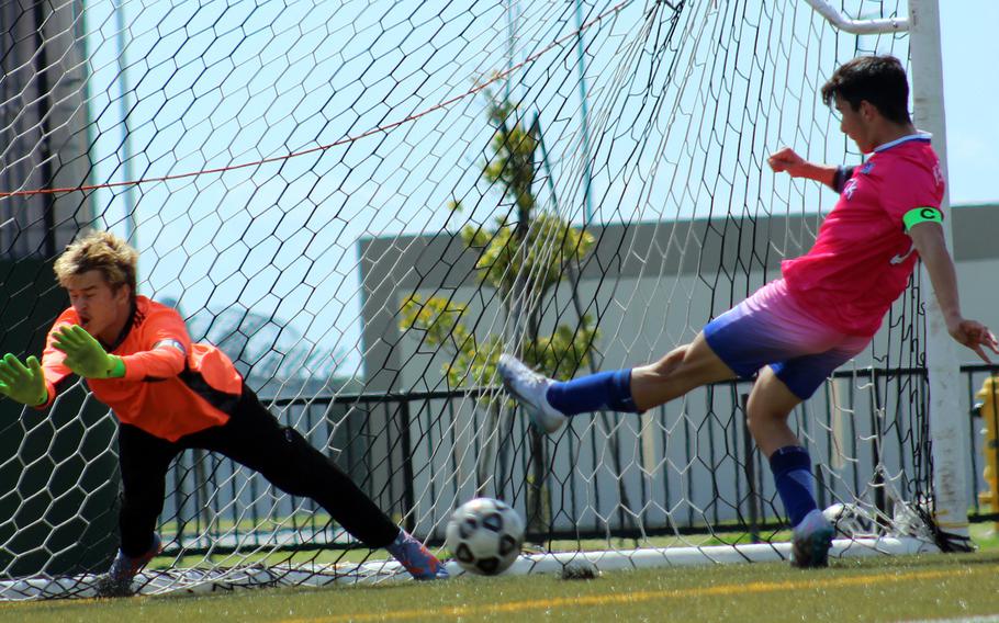 Nile C. Kinnick's Aidan Florespena tries to drive the ball past Matthew C. Perry goalkeeper Kirby Kendrick during Saturday's DODEA-Japan boys soccer match. The Red Devils won 6-0.