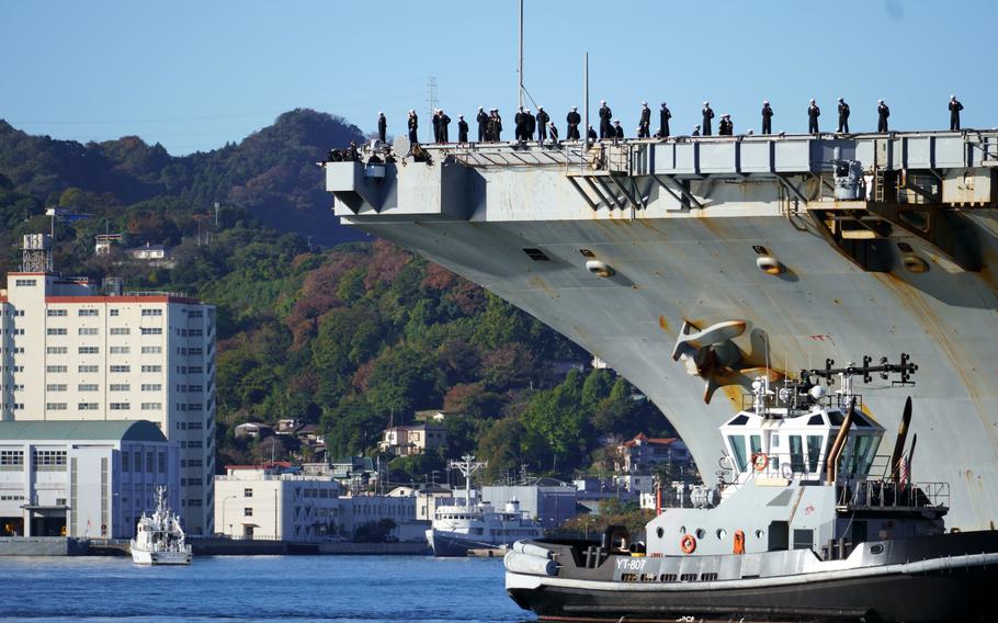 Sailors man the rails of the USS Ronald Reagan as the aircraft carrier returns to Yokosuka Naval Base, Japan, on Nov. 19, 2023.