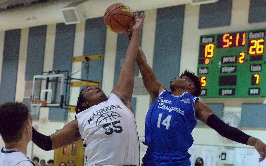 Daegu's Meiko Sowu and Osan's Jaylon Grant sky for a rebound during Friday's Korea boys basketball game. The Cougars edged the Warriors 73-70.