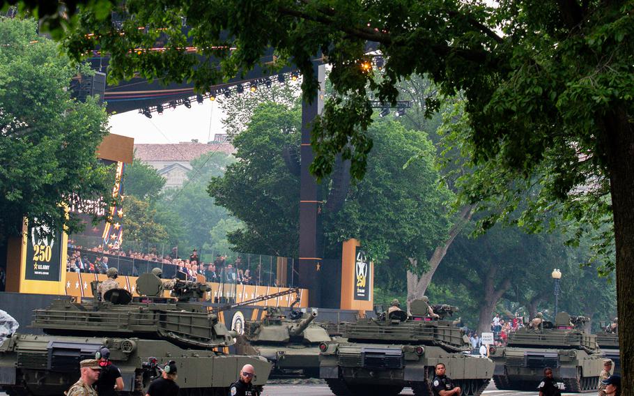 A line of tanks move down a city street.