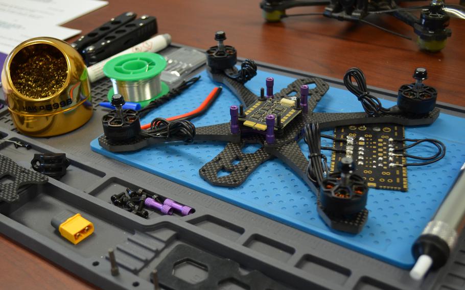 Parts for a small drone displayed on a table.