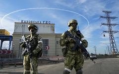 Russian troops guard an entrance of the Kakhovka Hydroelectric Station, a run-of-the-river power plant on the Dnieper River in Kherson region, southern Ukraine, May 20, 2022. 