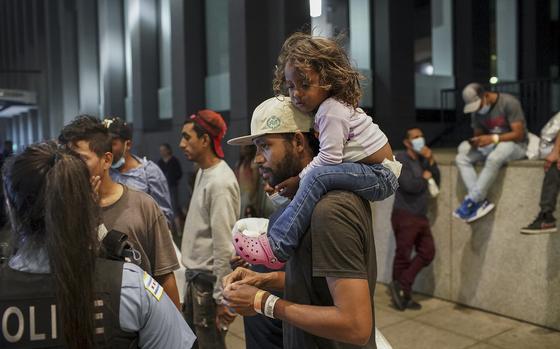 Elier Salazar Chacon, 29, carries his 3-year-old daughter Danieli Cataleya Salazar while talking with a Chicago police officer after arriving on a bus with 75 other migrants from Texas at Union Station on Aug. 31, 2022 in Chicago.