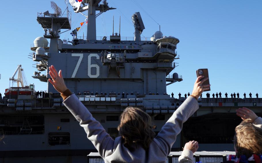 Sailors' family members cheer as the aircraft carrier USS Ronald Reagan returns to Yokosuka Naval Base, Japan, Friday, Dec. 16, 2022.