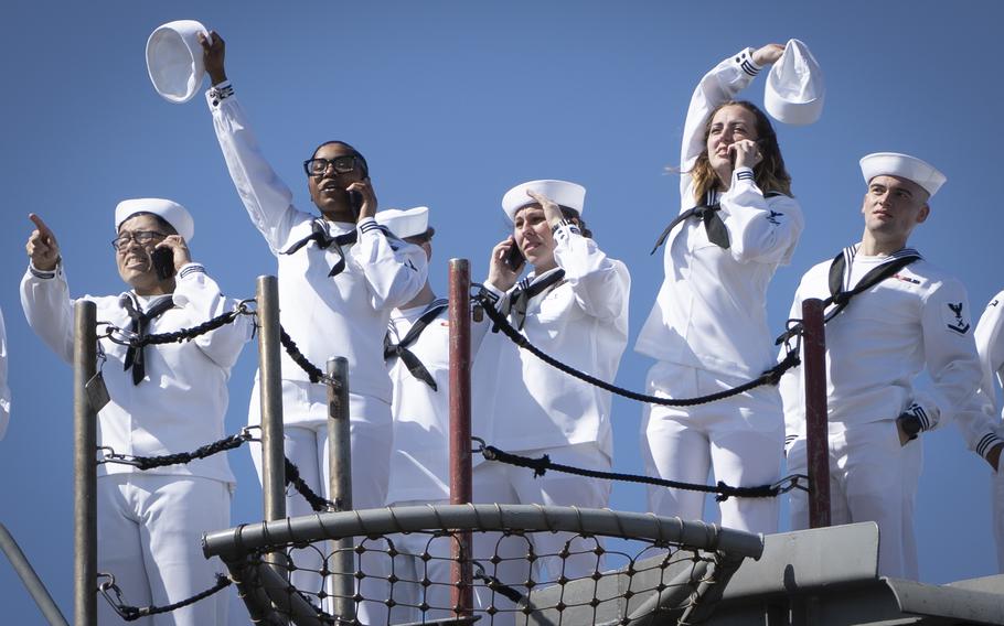 Sailors assigned to the USS George H.W. Bush wave to family members as the ship returns to Naval Station Norfolk, Sunday, April 23, 2023. 