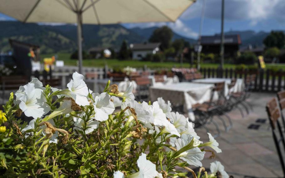 The outdoor terrace at Bun Viet in Unterammergau, Germany, offers a beer garden atmosphere with views of the surrounding Alps.