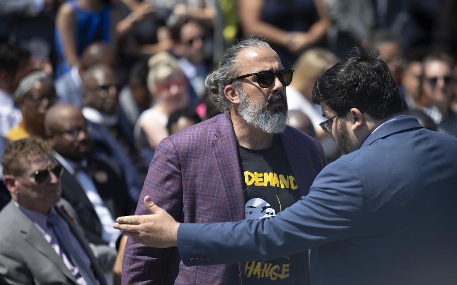 A White House staff member escorts Manuel Oliver from the audience during an event to celebrate the passage of the Bipartisan Safer Communities Act. Oliver's son died in the 2018 shooting in Parkland, Florida. 