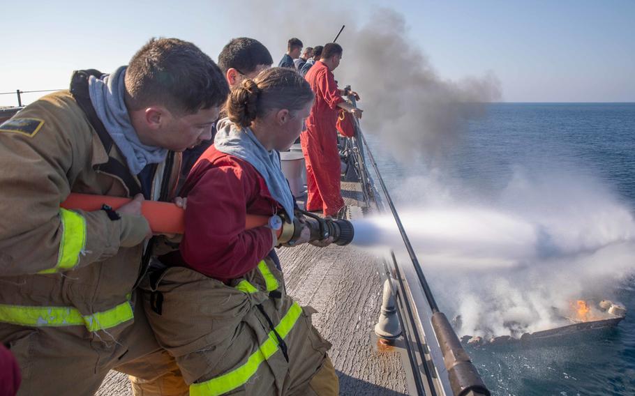 Sailors aboard the USS Nitze put out a fire on a  motorboat in the Gulf of Aden on Oct. 26, 2022.  They rescued three people from the craft before it sank.