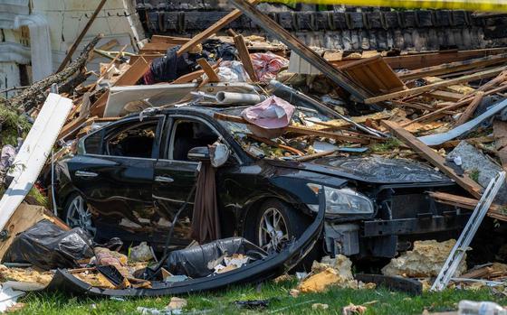 A vehicle damaged by debris sits in a driveway on Sunday, June 1, 2025, in Gladstone. The debris was scattered following a home explosion the day before that killed one person and damaged nearby houses.