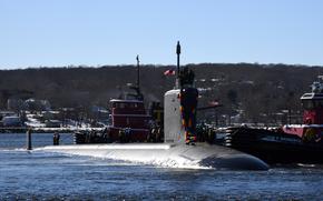 A submarine with decorations emerges from water.