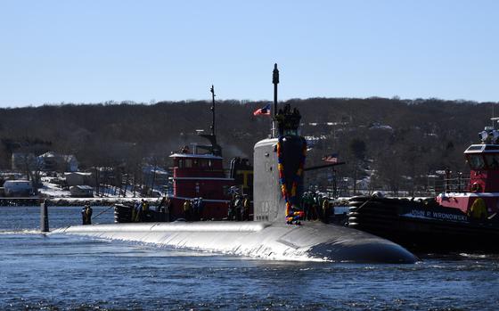 A submarine with decorations emerges from water.