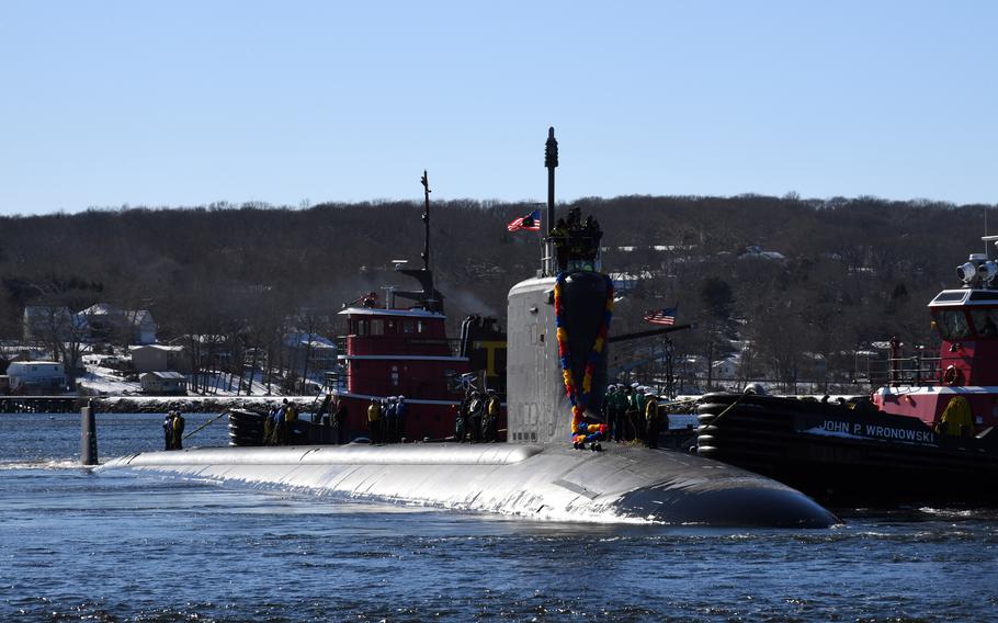 A submarine with decorations emerges from water.