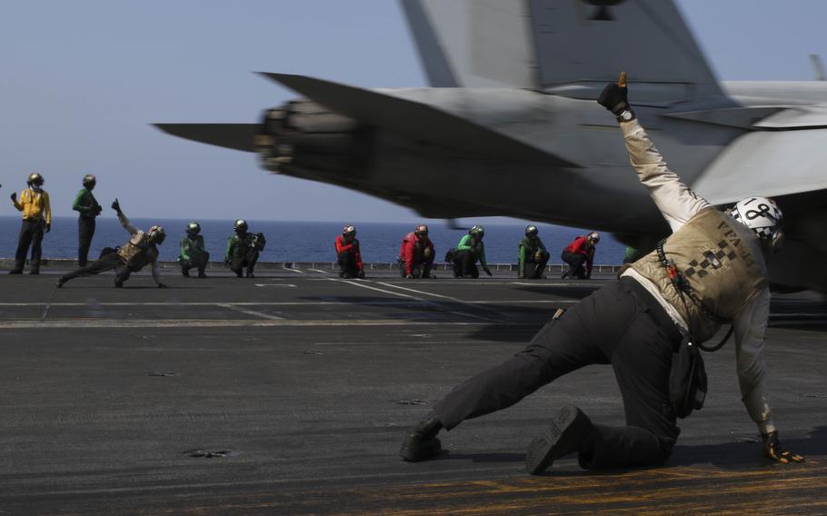 Sailors signal an F/A-18F Super Hornet, assigned to the “Black Aces” of Strike Fighter Squadron (VFA) 41, on the flight deck of the Nimitz-class aircraft carrier USS Abraham Lincoln (CVN 72) on March 24, 2022, while operating in the South China Sea. 