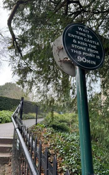 Sign reads: Wait time to enter castle and kiss the stone from this point is 90 minutes.
