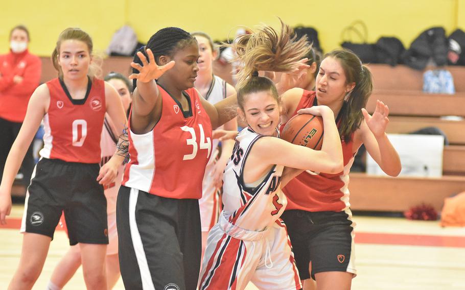 Aviano's Makinley Carroll fights to keep the ball against a host of American Overseas School of Rome defenders Thursday, March 3, 2022, at the DODEA-Europe Division II basketball championships.