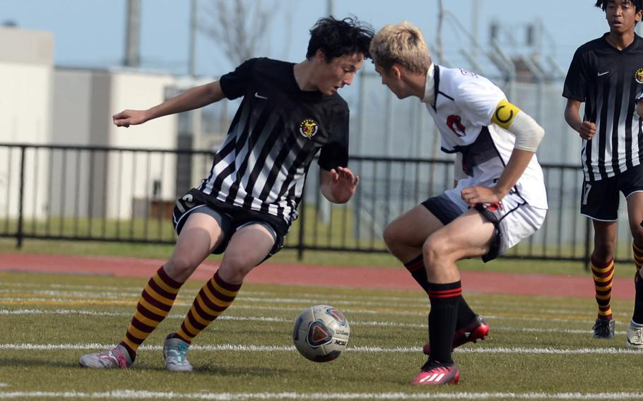 Matthew C. Perry's Preston Ramirez and E.J. King's Kai Sperl tangle for the ball during Friday's DODEA-Japan boys soccer match. The Cobras won 1-0.