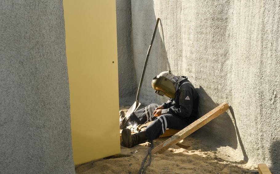 A worker welds a part of a steel blast door that will seal off one end of a renovated bunker at Ali Al Salem Air Base in Kuwait on Nov. 28, 2022. Military engineers designed upgraded bunkers after the Iranian missile strike on Al Asad Air Base on Jan. 8, 2020, led to more than 100 traumatic brain injuries, a statement by the U.S. Army Engineer Research and Development Center said.