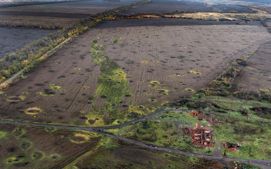 An aerial view of artillery craters scarring the landscape next to a destroyed house on Oct. 24, 2022, in Sulyhivka, Kharkiv oblast, Ukraine.
