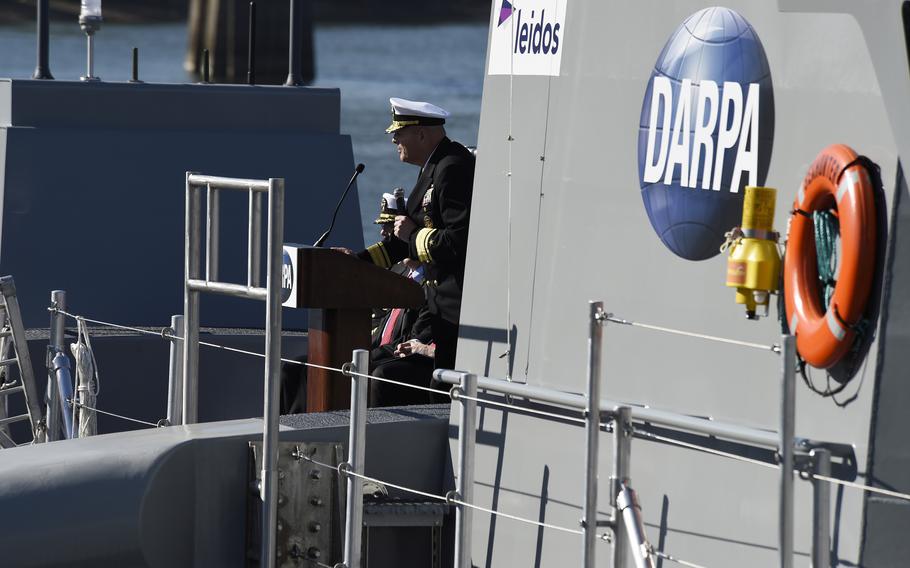 Rear Adm. Robert Girrier, then-director of unmanned warfare systems, speaks at a christening ceremony on April 7, 2016, for a vessel that was developed and built through the DARPA’s Anti-Submarine Warfare Continuous Trail Unmanned Vessel program. Through a new program, called In the Moment, DARPA wants to develop technology that would make quick decisions in stressful situations using algorithms and data.”