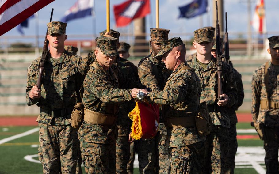 Col. Peter Eltringham, right, commander of the new 12th Marine Littoral Regiment, retires the 12th Marines’ unit colors along with Sgt. Maj. Joshua Minter at Camp Hansen, Okinawa, Wednesday, Nov. 15, 2023. 