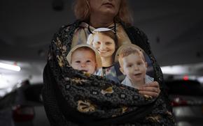 A woman holds photos of Shiri Bibas and her sons Kfir and Ariel, Israelis who are being held hostage in the Gaza Strip by the Hamas militant group, during a protest in Tel Aviv on Feb. 21, 2024.