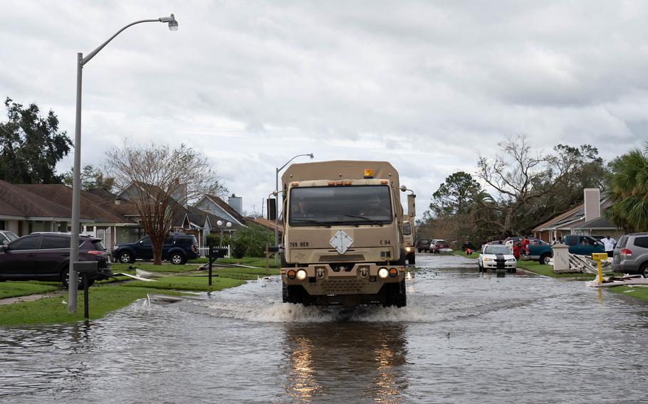 Louisiana National Guard members in high-water vehicles and boats work with St. John the Baptist Parish officials to rescue people stranded in their homes in the wake of Hurricane Ida. 