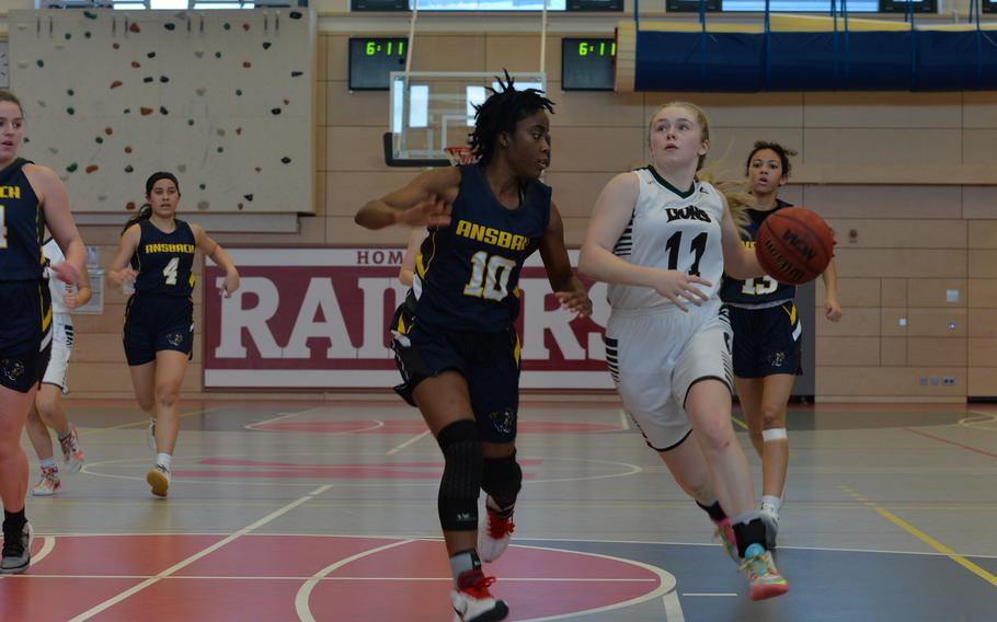 Tori Morris of the AFNORTH Lions pushes past Heaven Jackson of the Ansbach Cougars during the DODEA-Europe Division III girls basketball title game in Kaiserslautern, Germany, on Saturday, Feb. 26, 2022.