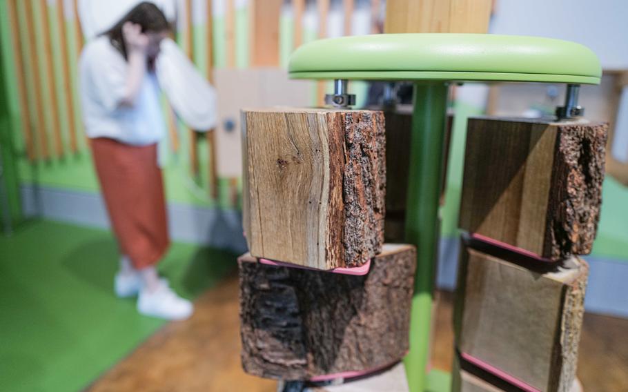 A visitor listens to an audio guide at a nature station, learning about how trees grow and the science behind their development at the Experimenta Science Center in Heilbronn, Germany.