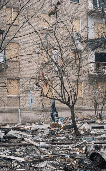 Clothing hangs from trees outside a building a Russian missile struck. 
