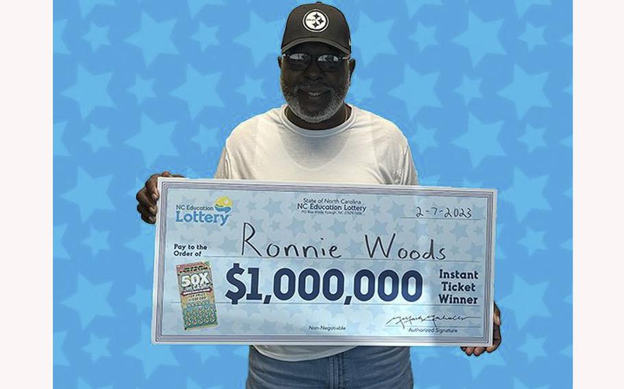 Ronnie Woods, a veteran of the Navy and Marine Corps, holds a check showing his lottery prize.
