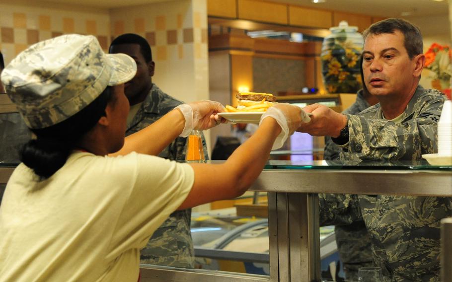 Airman 1st Class Ashli Green of the 628th Force Support Squadron hands an airman a plate at the dining facility at Joint Base Charleston, S.C., in 2012. 