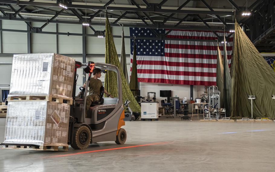 An airman with the 721st Aerial Port Squadron helps unload baby formula at Ramstein Air Base, Germany on May 21, 2022, before it was flown to the United States to help ease a national shortage. 