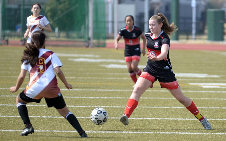 E.J. King’s Madylyn O’Neill sends the ball past Marist Brothers’ Aanya Jhaveri during Saturday’s Western Japan Athletic Association girls small-schools soccer tournament final. The Cobras won 2-1.